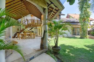 a house with a patio with a table and chairs at Mayana Villas in Canggu