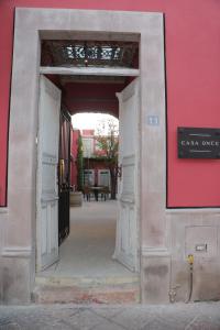 an open door to a building with a red wall at Hotel Casa Once in Querétaro