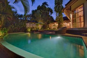 a swimming pool in the backyard of a house at Mayana Villas in Canggu