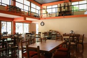 ein Restaurant mit Holztischen und -stühlen und Fenstern in der Unterkunft Vista Potrero - Hotel, Camping & Events in Hidalgo
