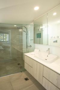 a bathroom with a sink and a glass shower at Oceanside Resort - Absolute Beachfront Apartments in Gold Coast