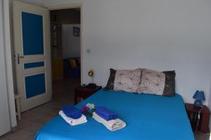 a bedroom with a blue bed with towels on it at Maria Appart BAYALOCATION in Les Trois-Îlets