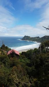 vista su una spiaggia con una casa e l'oceano di Cabañas Emma Maicolpue a Osorno