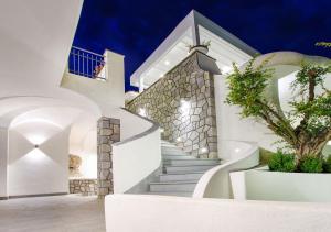 una escalera que conduce a un edificio blanco con un árbol en Villa Caruso, en Isquia