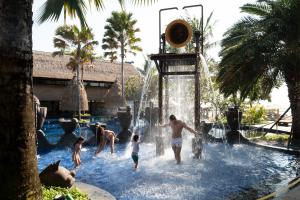 Holiday Inn Resort Bali Nusa Dua, an IHG Hotel - CHSE Certified في نوسا دوا: مجموعة من الناس يلعبون في الحديقة المائية