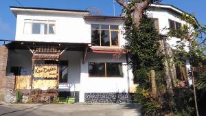 ein weißes Haus mit einem Baum davor in der Unterkunft Villa KenDedes Garden in Batu