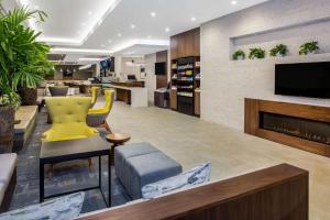 a lobby with a yellow chair and a fireplace at Wyndham Garden Ft Lauderdale Airport & Cruise Port in Dania Beach