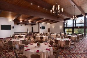 un salón de banquetes con mesas y sillas blancas en Wyndham Garden State College en State College
