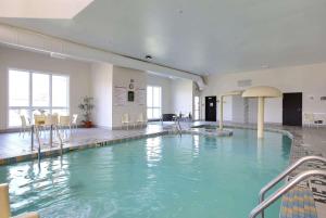 a large swimming pool in a building with blue water at Super 8 by Wyndham Trois-Rivieres in Trois-Rivières