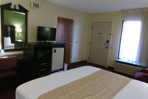 a hotel room with a bed and a television at Travelodge by Wyndham Knoxville East in Knoxville