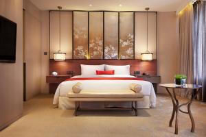 a bedroom with a large bed and a television at HUALUXE Shanghai Twelve At Hengshan, an IHG Hotel in Shanghai