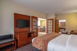 a hotel room with a bed and a flat screen tv at Comfort Suites NW Dallas Near Love Field in Dallas