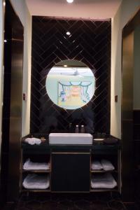 a bathroom with a sink and a mirror at Moon and Chalice Boutique Hotel in Kunming