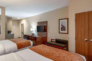a hotel room with two beds and a flat screen tv at Comfort Suites NW Dallas Near Love Field in Dallas