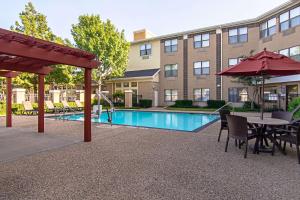 a patio with a table and chairs and a pool at Comfort Suites NW Dallas Near Love Field in Dallas
