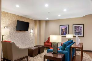 uma sala de estar com um sofá e cadeiras e uma televisão em Comfort Inn & Suites At Copeland Tower em Metairie