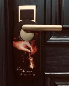a door with a picture of a person holding a toilet at Moon and Chalice Boutique Hotel in Kunming
