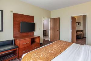 a hotel room with a bed and a flat screen tv at Comfort Suites NW Dallas Near Love Field in Dallas