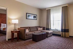 a hotel room with a couch and a bed at Comfort Suites NW Dallas Near Love Field in Dallas