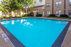 a large blue swimming pool in front of a building at Comfort Suites NW Dallas Near Love Field in Dallas