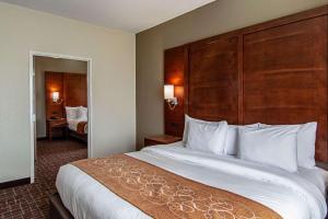 a hotel room with a large bed with a large headboard at Comfort Suites NW Dallas Near Love Field in Dallas