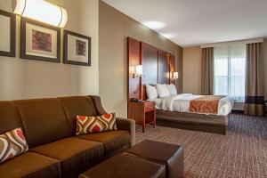 a hotel room with a bed and a couch at Comfort Suites NW Dallas Near Love Field in Dallas