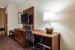a room with a desk with a lamp and a television at Comfort Suites NW Dallas Near Love Field in Dallas