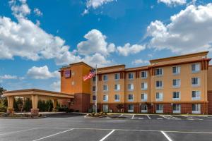 un hôtel arborant un drapeau américain dans un parking dans l'établissement Comfort Suites, à Seaford