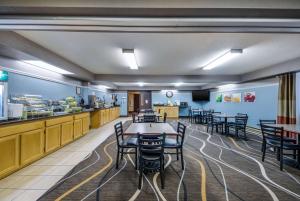 a dining room with tables and chairs and a kitchen at Quality Inn & Suites in Newberry