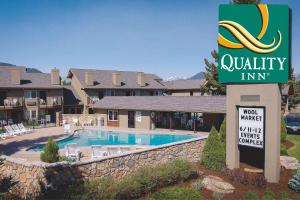 a sign in front of a hotel with a swimming pool at Quality Inn near Rocky Mountain National Park in Estes Park