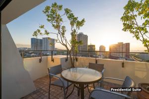 a balcony with a table and chairs and a view of the city at Orchid Garden Suites in Manila