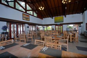 a restaurant with wooden tables and chairs and windows at Sutera @ Mantanani Island Resort & Spa in Mantanani Island