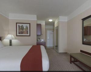 a large hotel room with a bed and a table at Holiday Inn Express Hotel & Suites San Dimas, an IHG Hotel in San Dimas