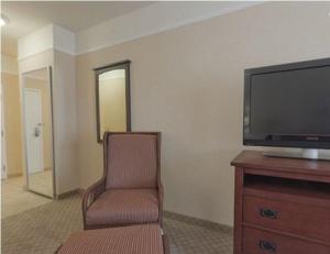 
a living room with a chair and a tv at Holiday Inn Express Hotel & Suites San Dimas, an IHG Hotel in San Dimas
