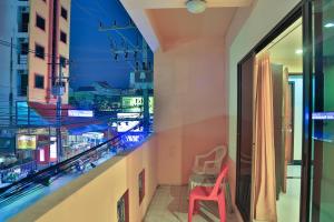 a red chair in a room with a balcony at Harrys Hotel Bar & Restaurant in Pattaya Central