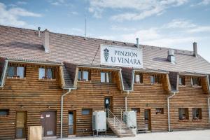 un edificio de madera con un cartel encima en Penzión u Vinára, en Veľký Krtíš