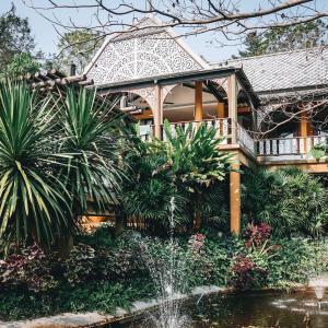 a house with a fountain in front of a garden at Kongkarn Resort and Farmstay in Ban Pak Ngam