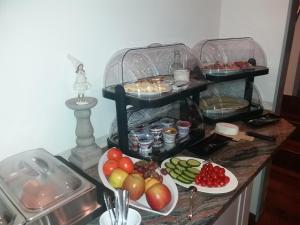 un mostrador con tres estanterías llenas de diferentes tipos de comida en Hotel Birkensee en Hannover