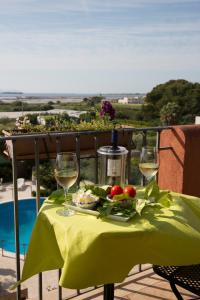 - une table avec une assiette de nourriture et des verres à vin dans l'établissement Hotel Isola Di Mozia, à Marsala