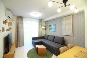 a living room with a couch and a tv at W&M House in Kanazawa