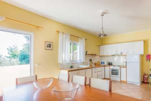 ヴァシリコスにあるDorettaのキッチン(テーブル、椅子付)、大きな窓が備わります。