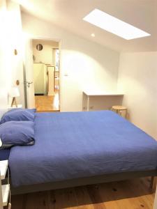 モワサックにあるLe T2 moderne des Palmiers au coeur de Moissacのベッドルーム1室(大型ベッド1台、青いシーツ付)