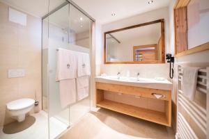 W łazience znajduje się umywalka, toaleta i lustro. w obiekcie Hotel Trattlerhof w mieście Bad Kleinkirchheim