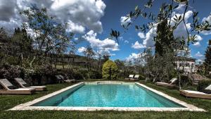 a swimming pool in the middle of a yard with lounge chairs at Villa Bordoni in Greve in Chianti