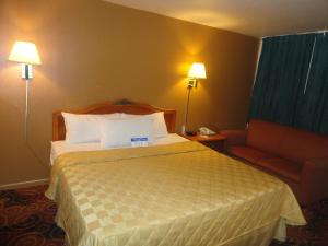 Americas Best Value Inn Santa Rosa, New Mexico في سانتا روزا: غرفه فندقيه بسرير واريكه