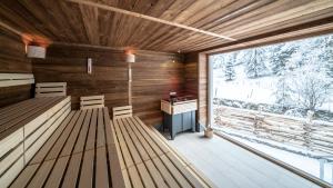 a sauna with benches and a desk and a window at Hotel Trattlerhof in Bad Kleinkirchheim