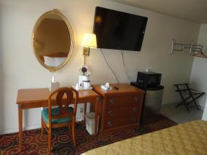 a hotel room with a desk and a mirror at Americas Best Value Inn Santa Rosa, New Mexico in Santa Rosa