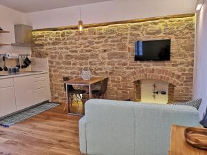 un soggiorno con divano e muro di mattoni di Loft Bellavista Volterra a Volterra