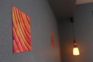 a painting hanging on a wall next to a light at Hotel Banister Kyoto in Kyoto