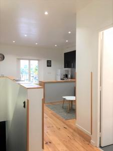 an open kitchen and living room with a table at Le T2 moderne des Palmiers au coeur de Moissac in Moissac